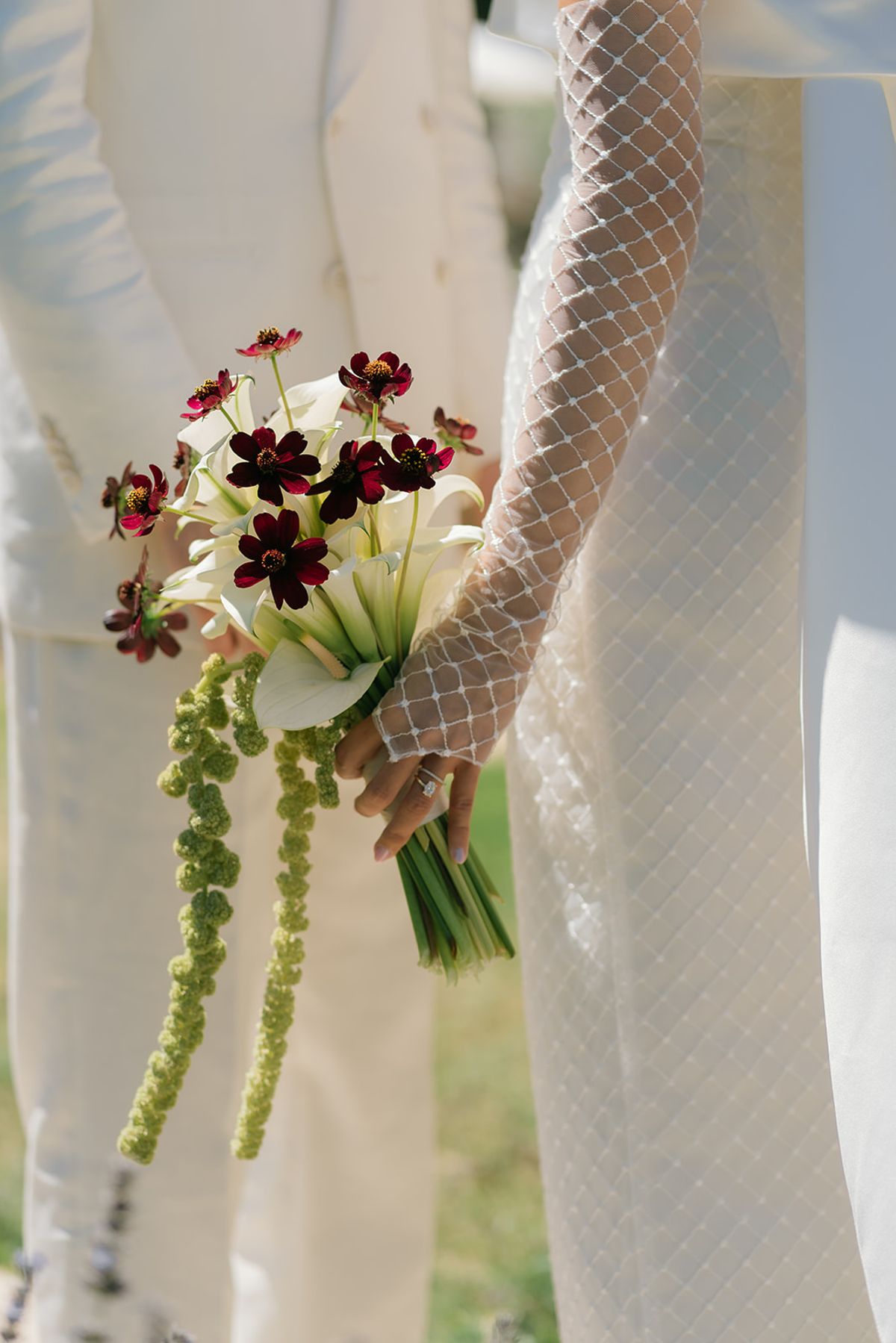 The bride's bouquet of white calla lilies, dark red cosmos and trailing green amaranthus