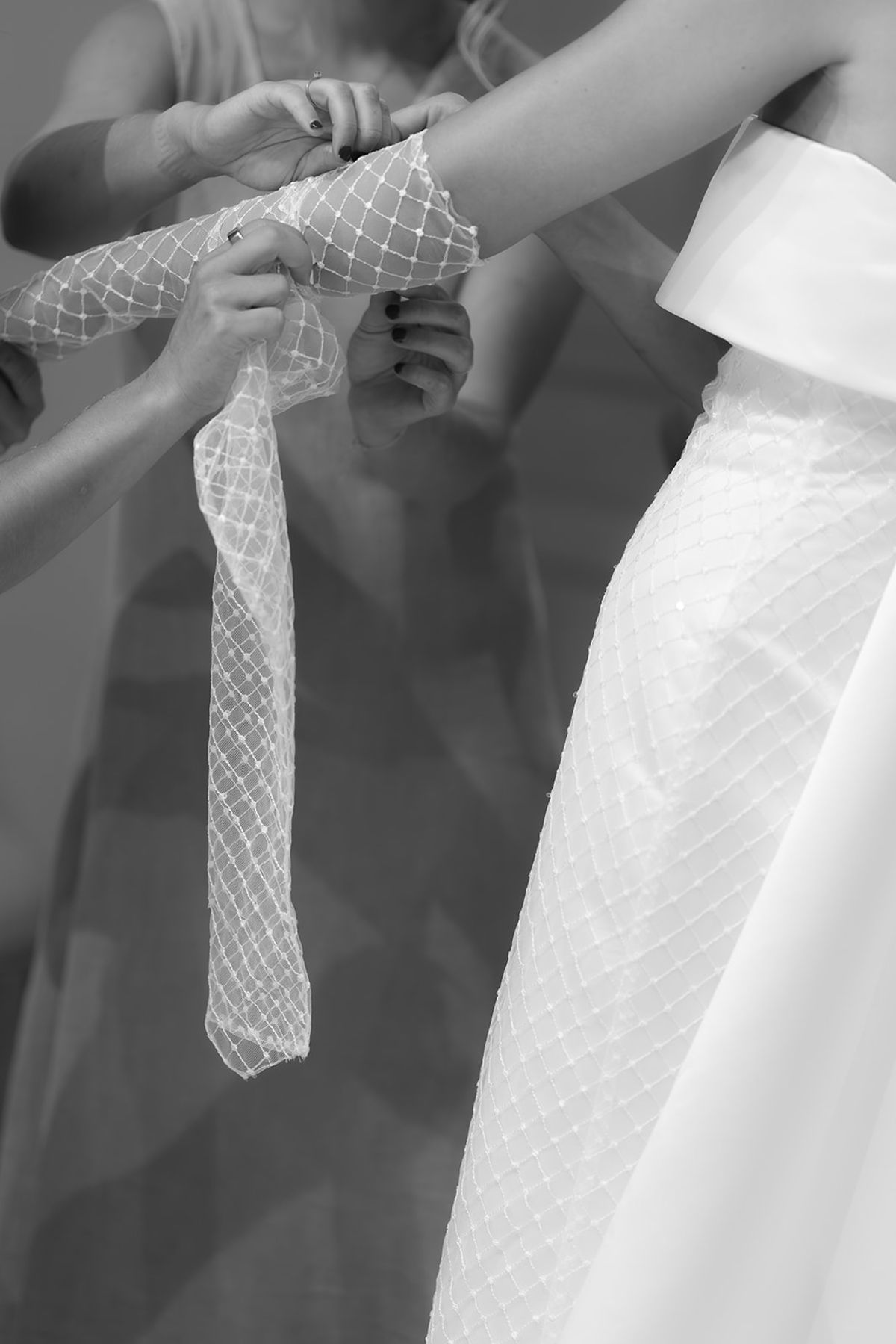 The bride's lattice-pattern sleeve being fastened before the ceremony