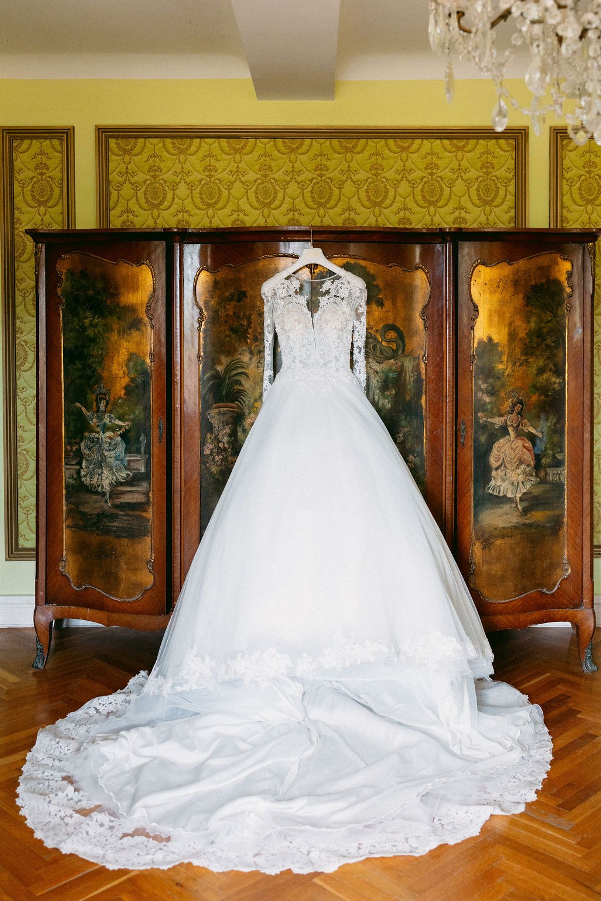 The bride's voluminous ball gown displayed before a painted cabinet at Château de Robernier