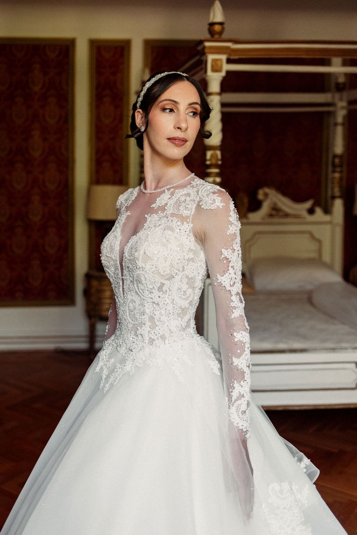 The bride in her lace-sleeved gown in a panelled room at Château de Robernier