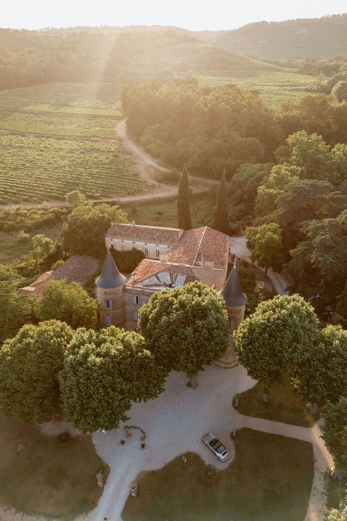 Aerial view of Château de Robernier set among vineyards and wooded hills