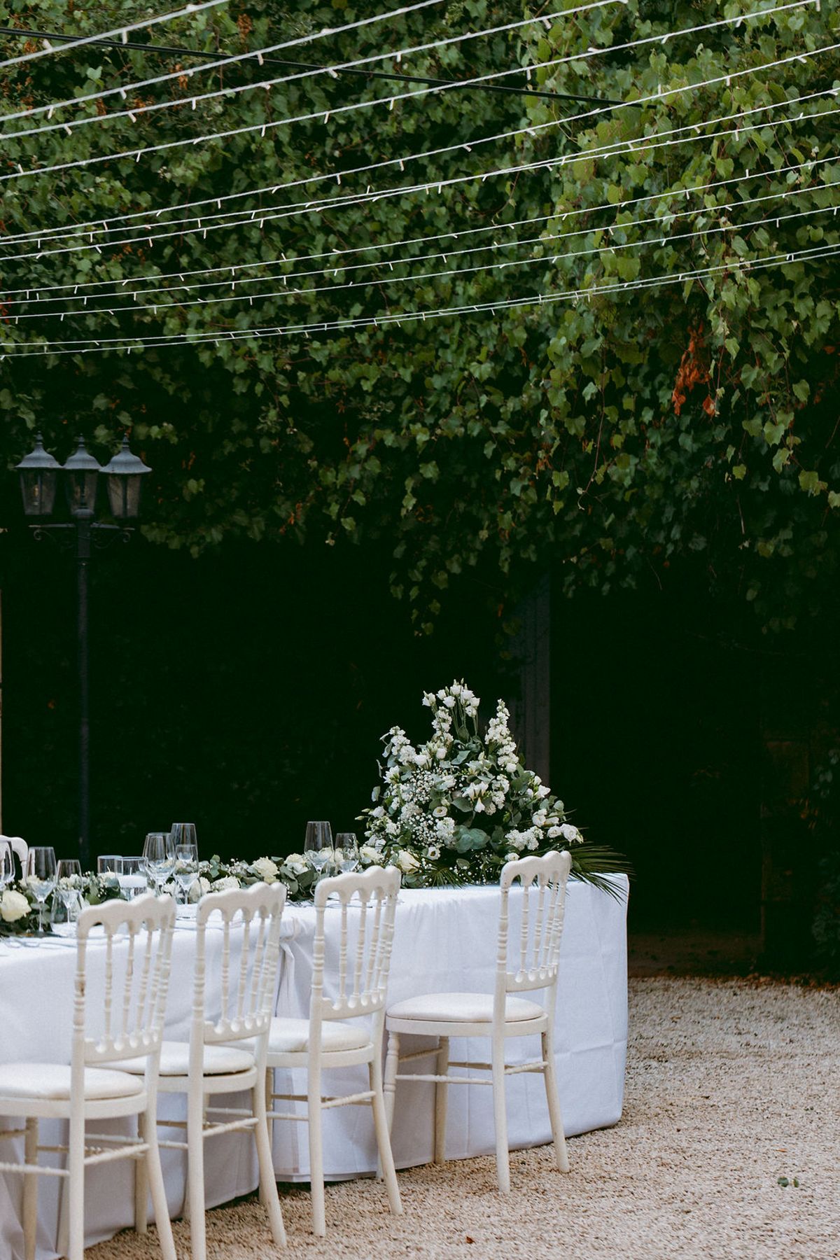The courtyard dinner tables set beneath festoon lights at Château de Robernier