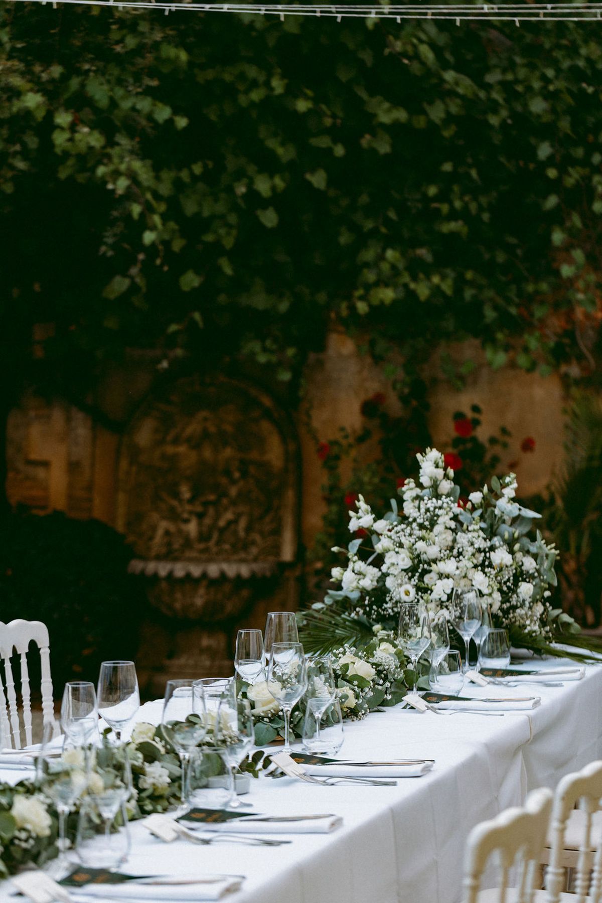 White blooms and eucalyptus running along the courtyard banquet table