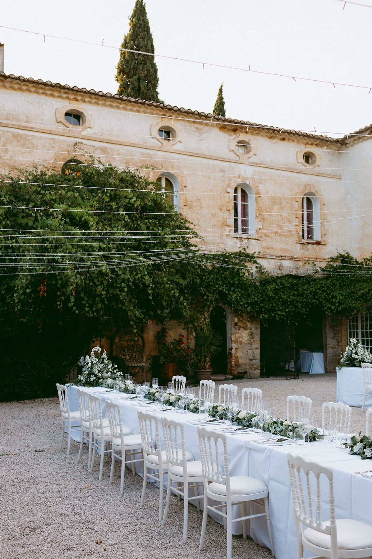 The long banquet table set in the courtyard before the chateau facade
