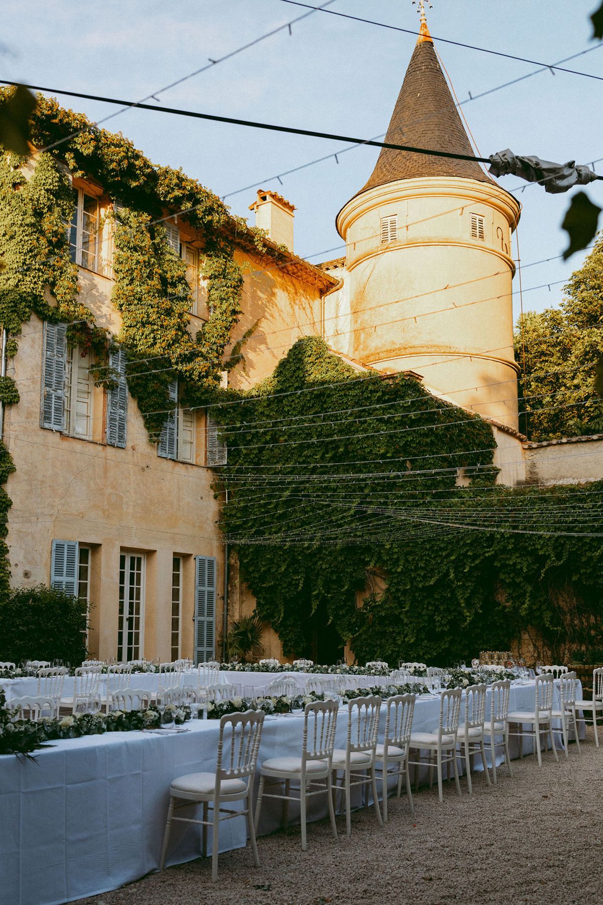Courtyard dining tables below the chateau turret at Château de Robernier