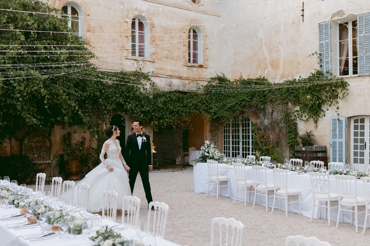 Ilenia and Dalil beside the banquet table in the ivy-covered courtyard