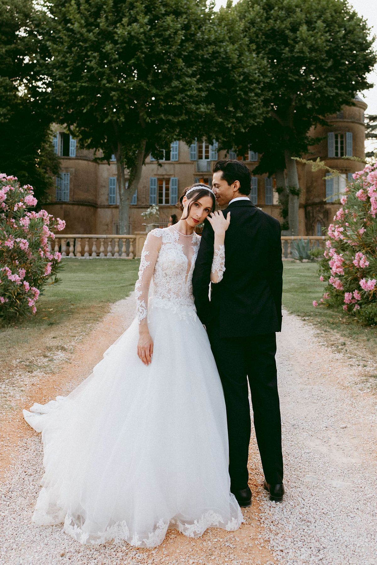 Ilenia and Dalil together on the gravel path beside flowering oleander