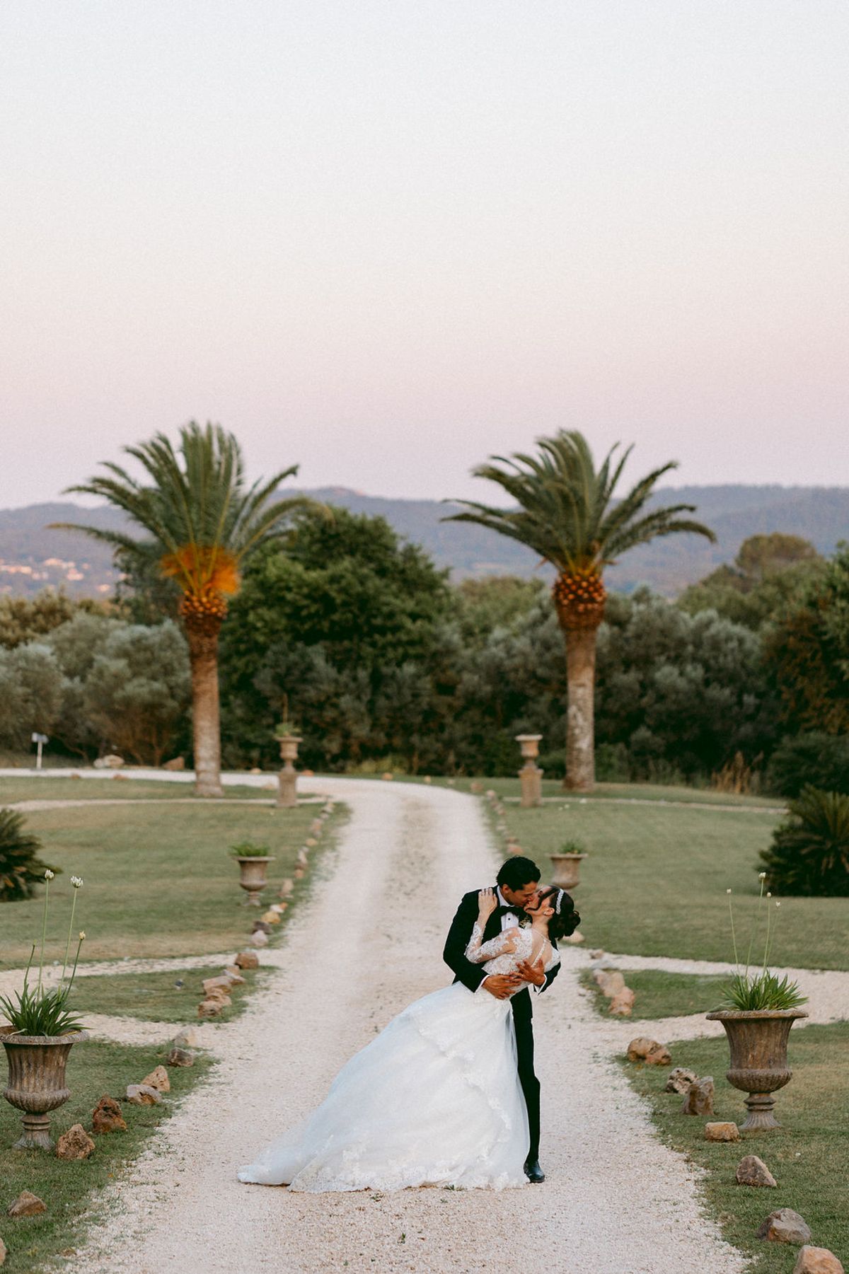 Ilenia and Dalil on the palm-lined drive at dusk
