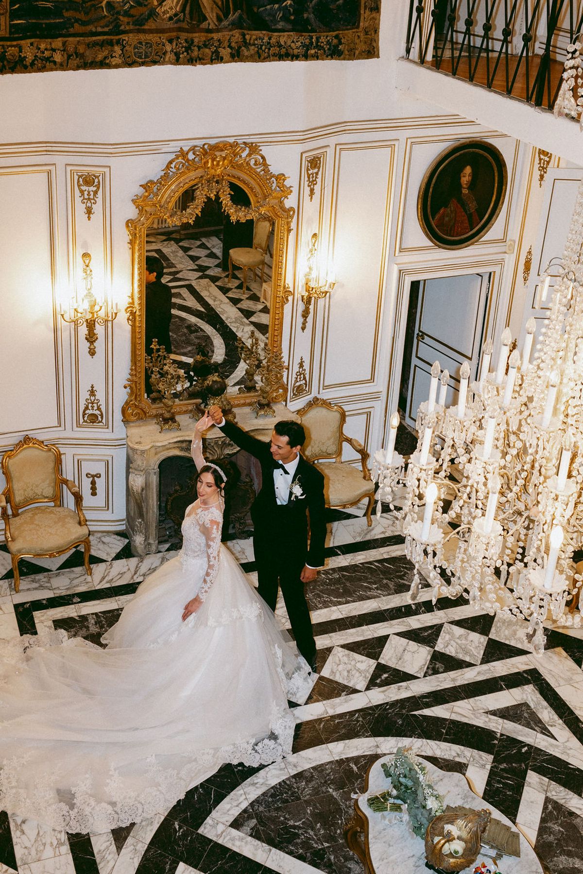 Ilenia and Dalil on the black and white marble floor of the chateau hall