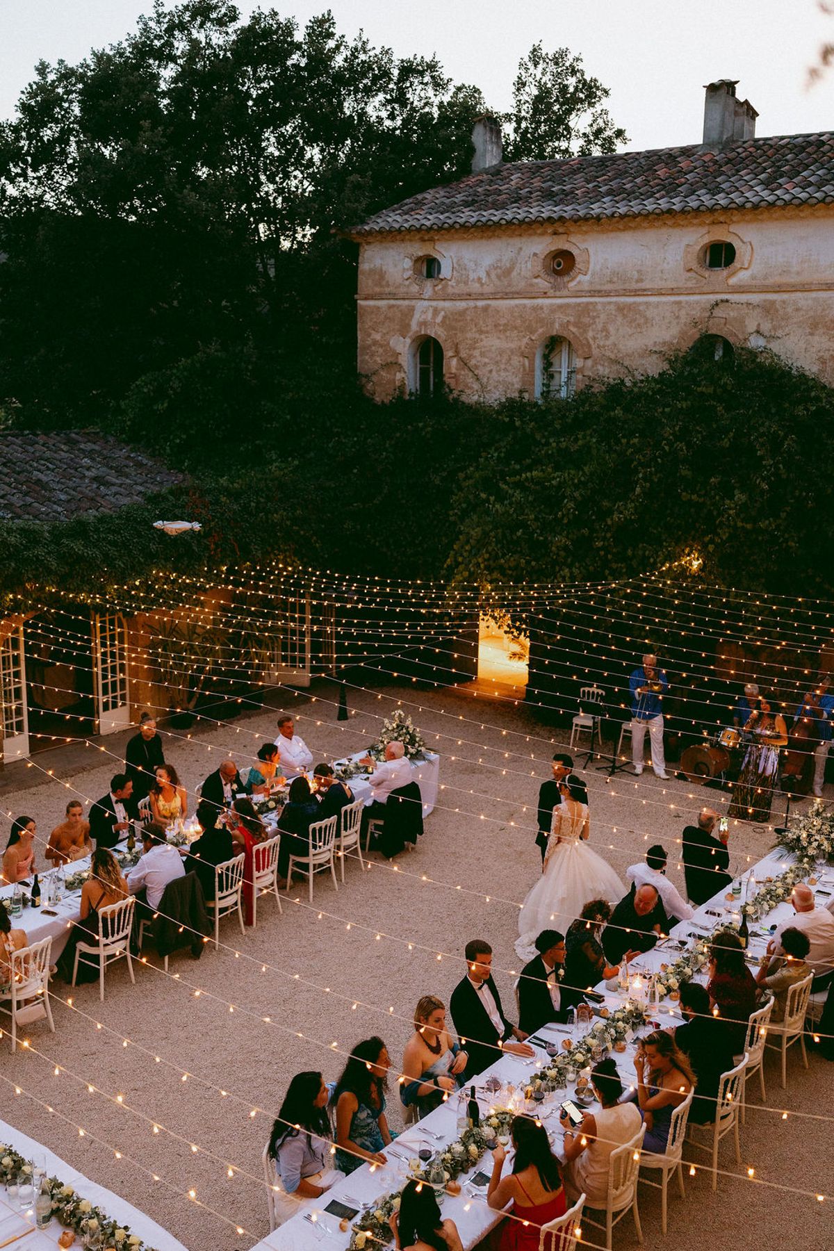 The courtyard dinner under festoon lights after dark