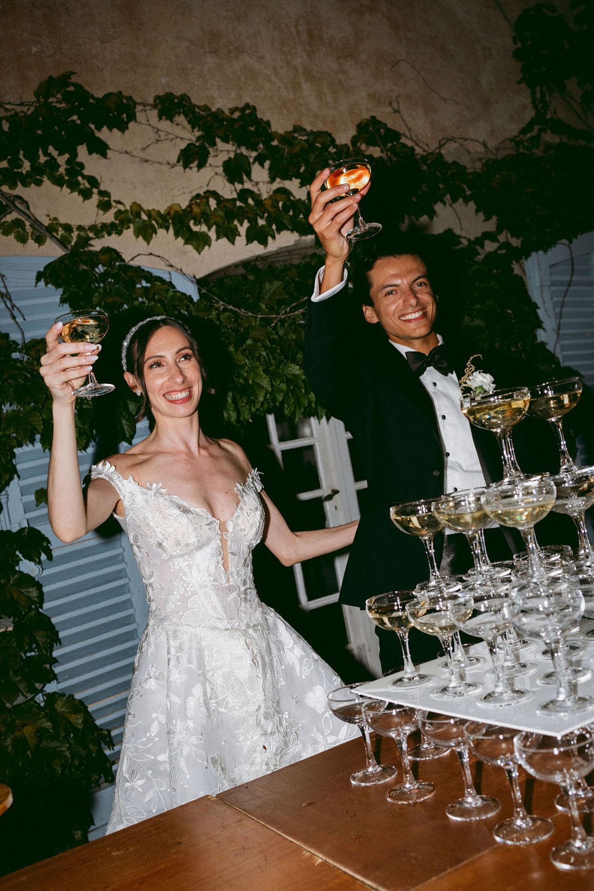 Ilenia and Dalil raising a glass beside the champagne tower