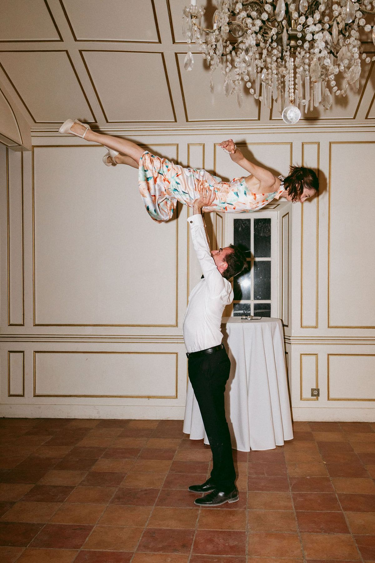 The groom lifting the bride in a salon at Château de Robernier