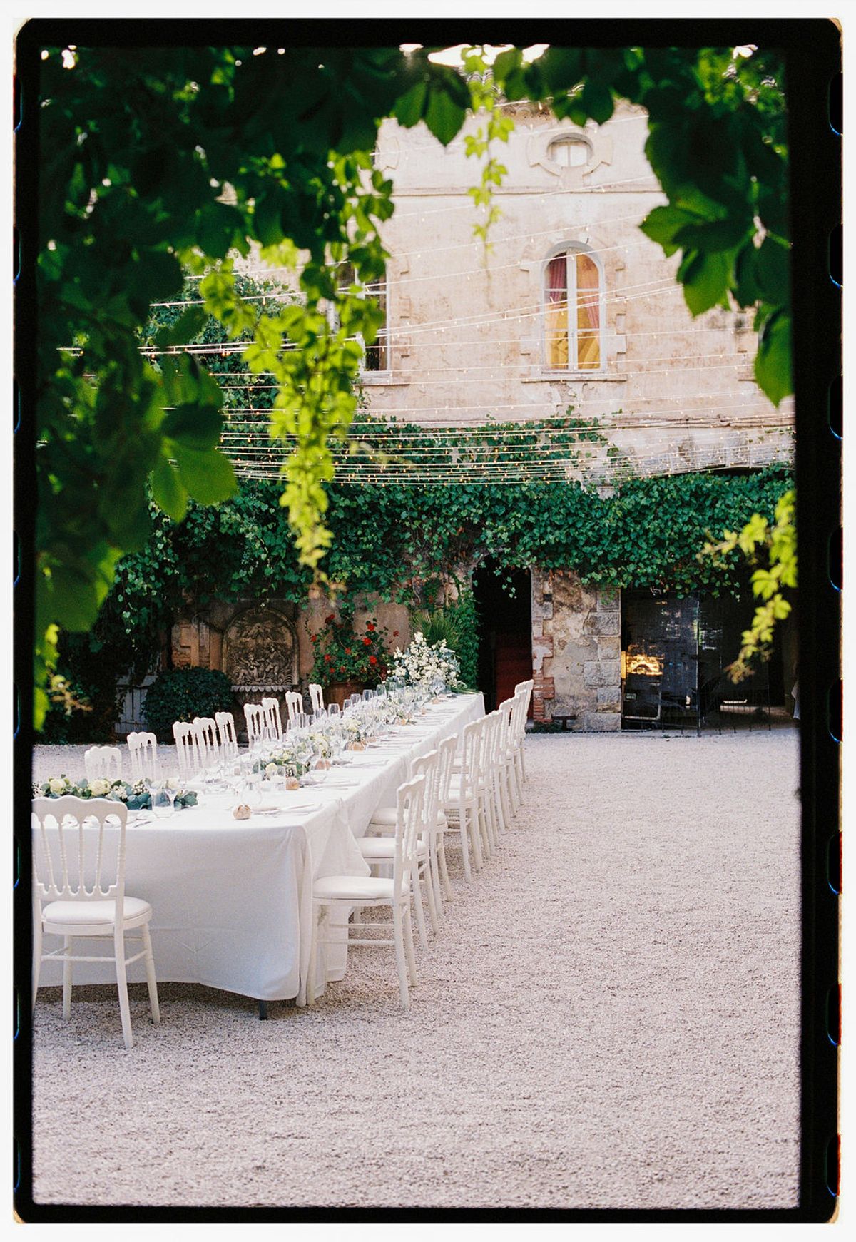 Film photograph of the courtyard banquet table against the ivy-clad chateau