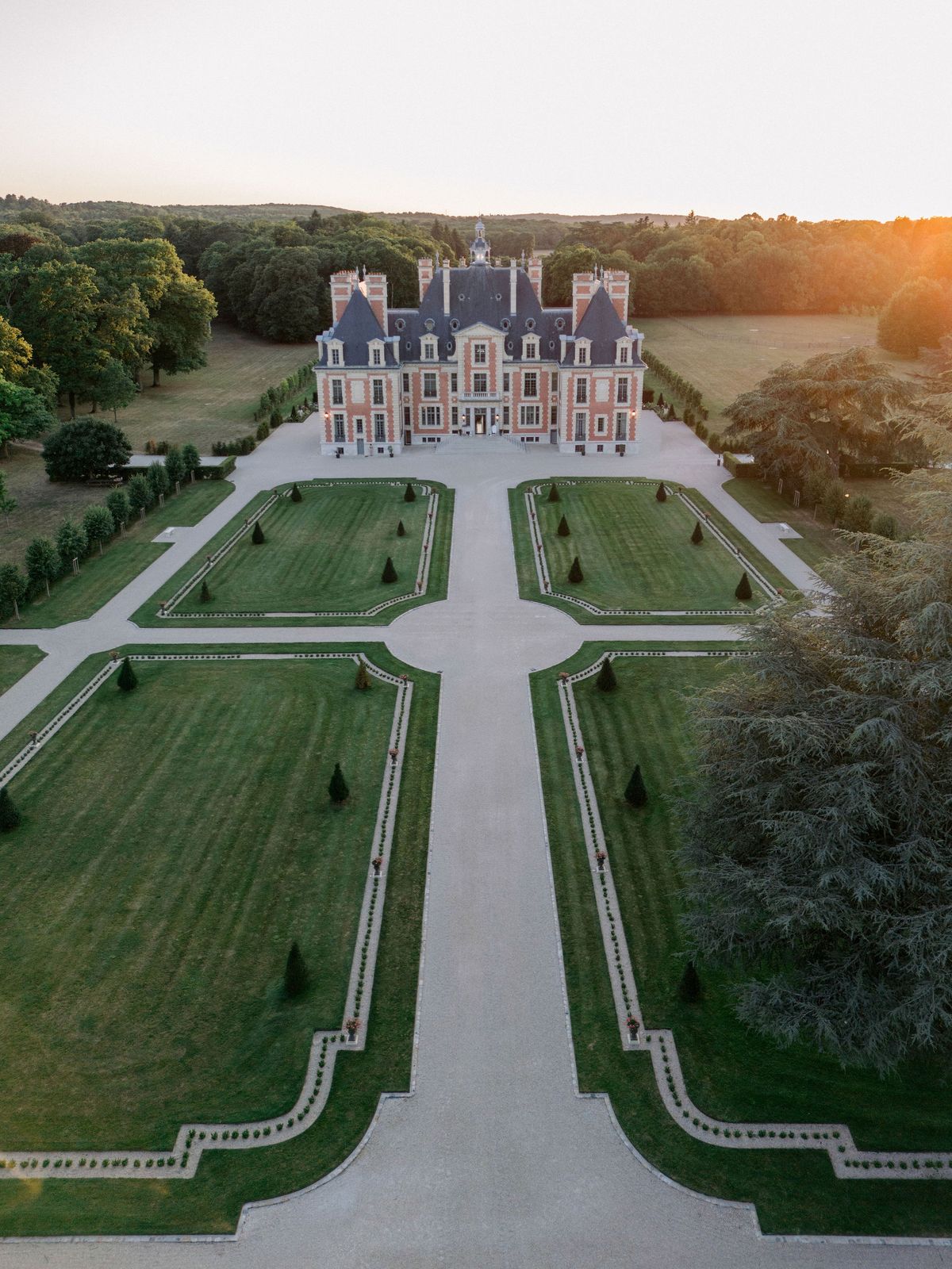 Aerial view of Chateau de Nainville-les-Roches and its formal French gardens at sunset