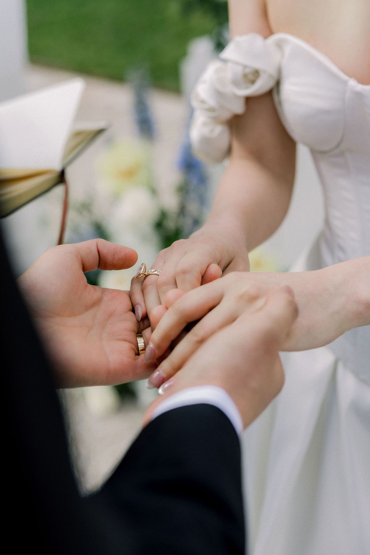Close-up of the groom placing the ring on the bride's finger