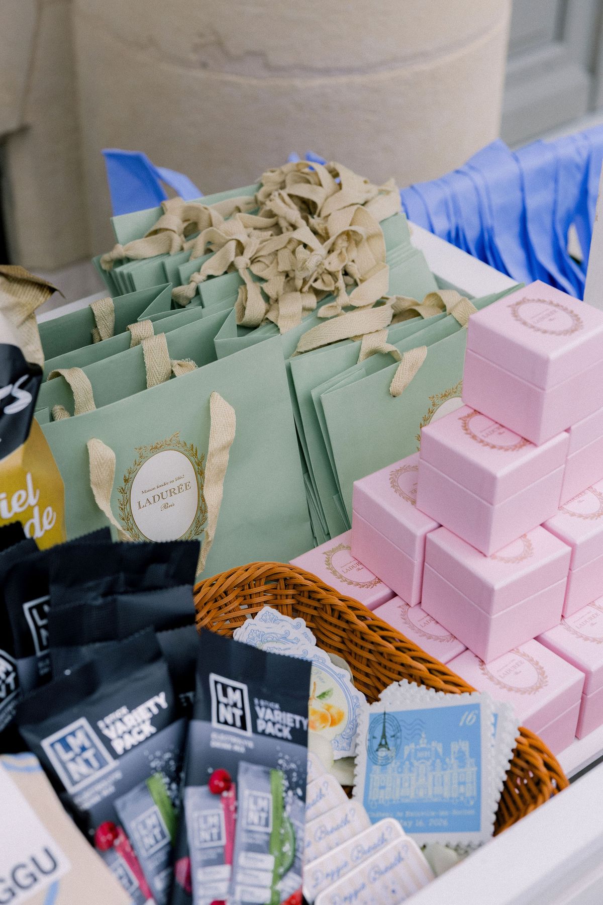 Pink Ladurée boxes, green gift bags and crisps packed into the favour cart