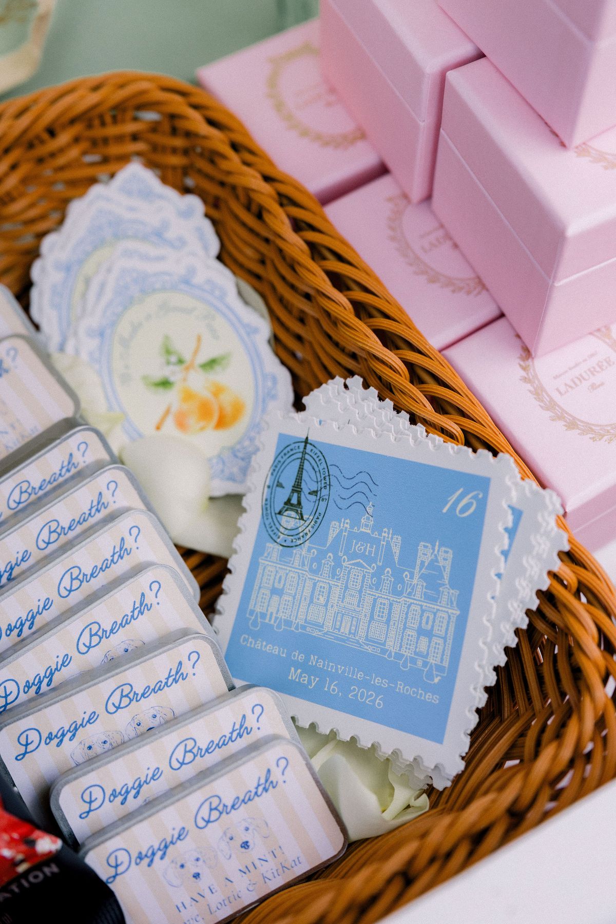 A blue stamp-shaped card illustrated with the chateau in a basket of mint tins