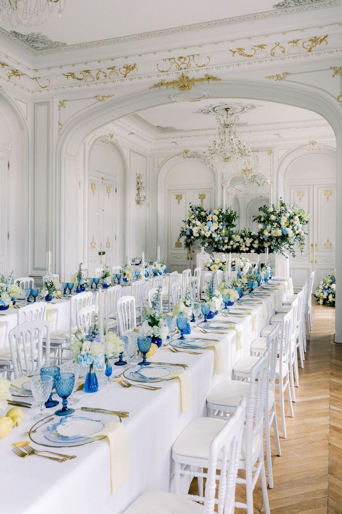 The dinner tables laid down the salon towards the flower-banked top table
