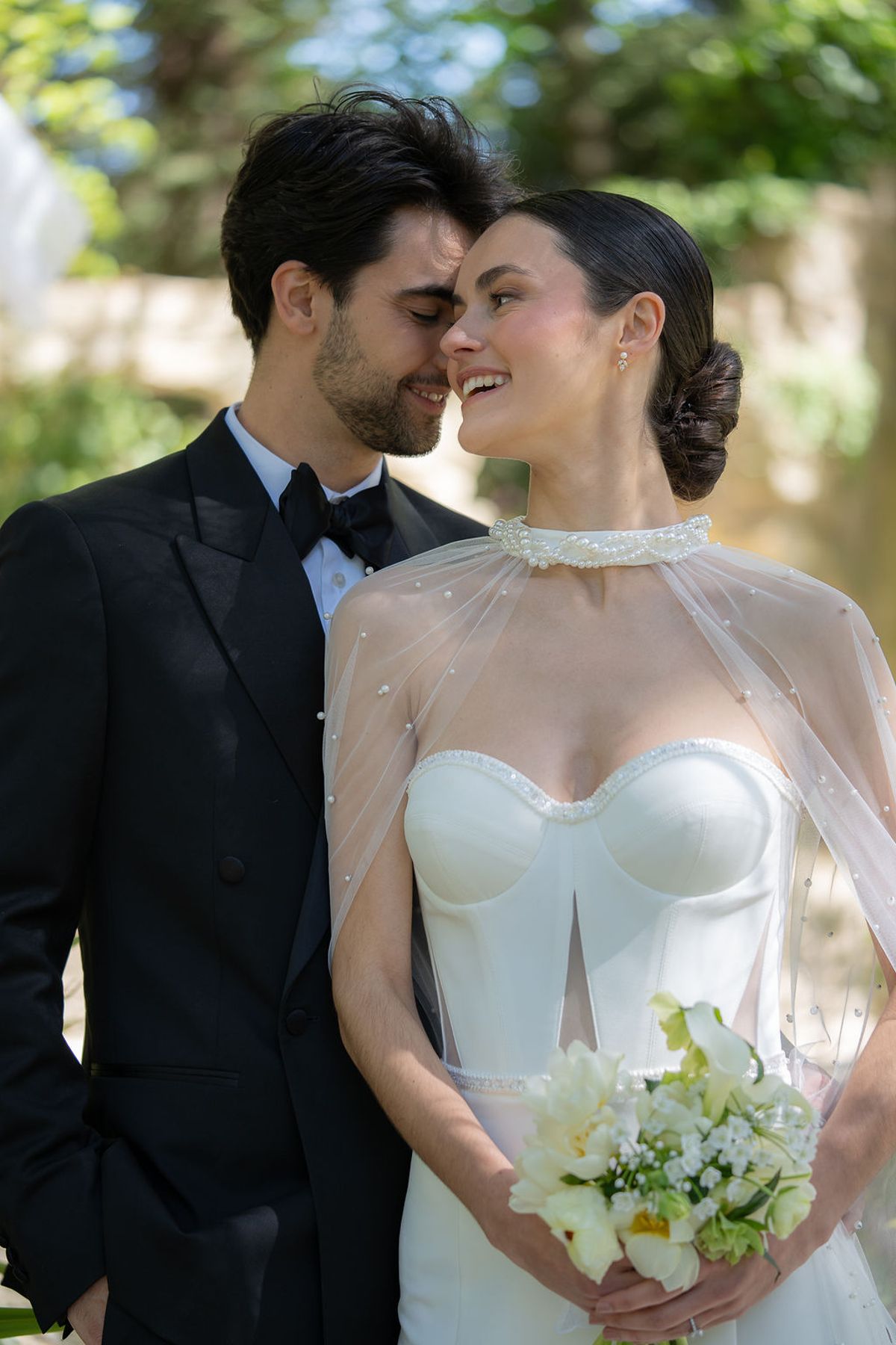 Two dancers close together, one holding a bouquet of white and yellow blooms