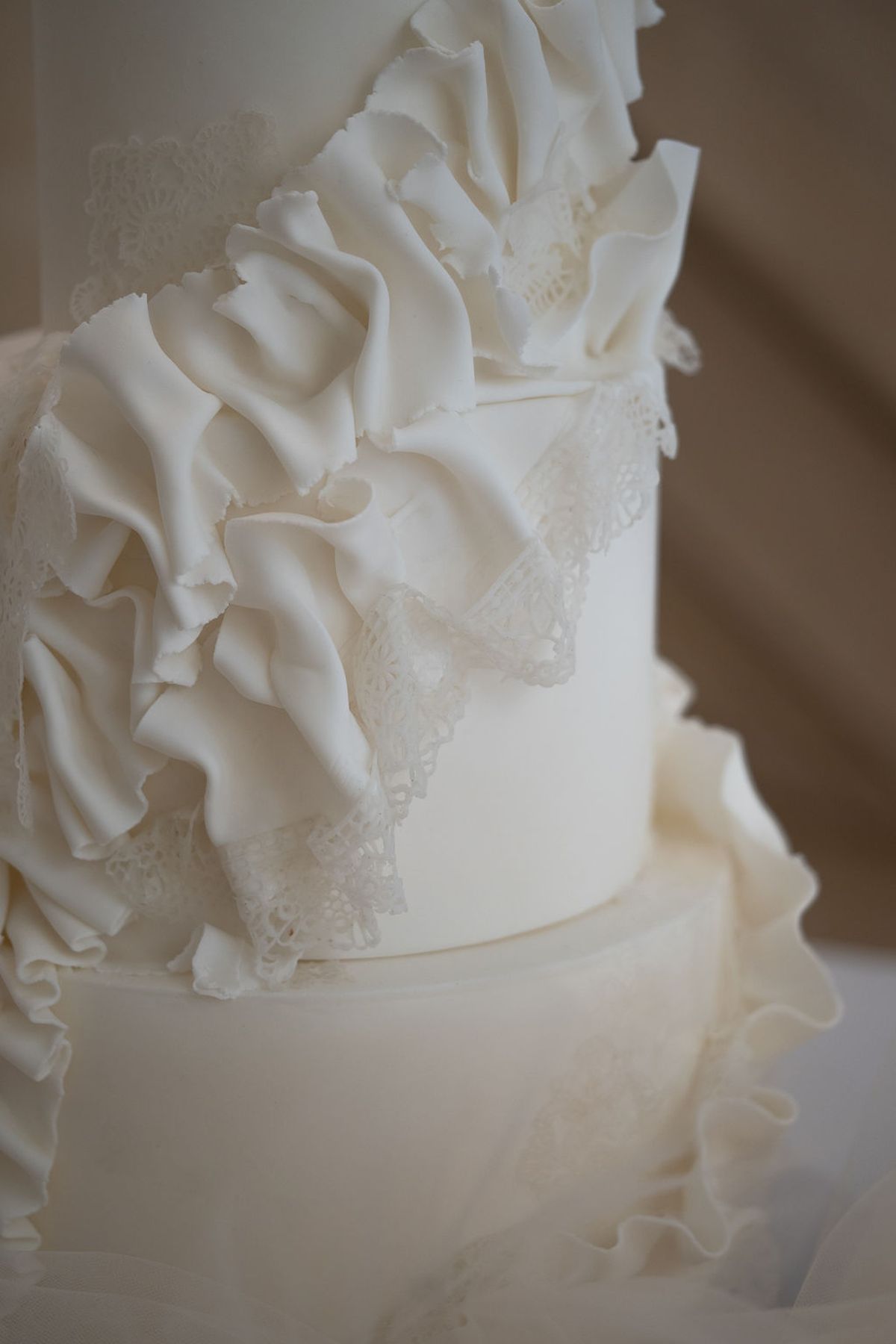 Close detail of a white ruffled tiered wedding cake
