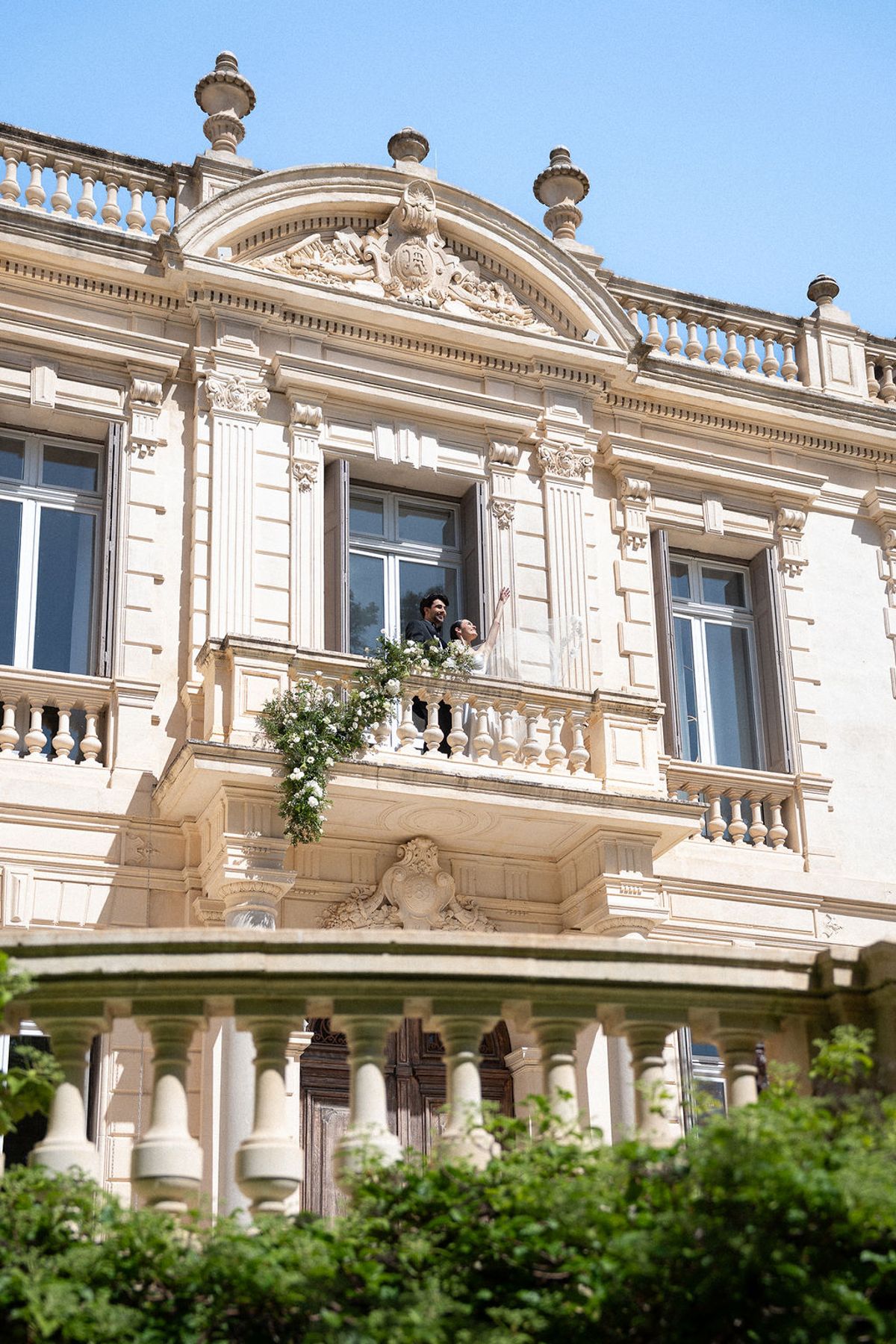 Carved stone facade and first-floor balcony of Château des Trois Fontaines