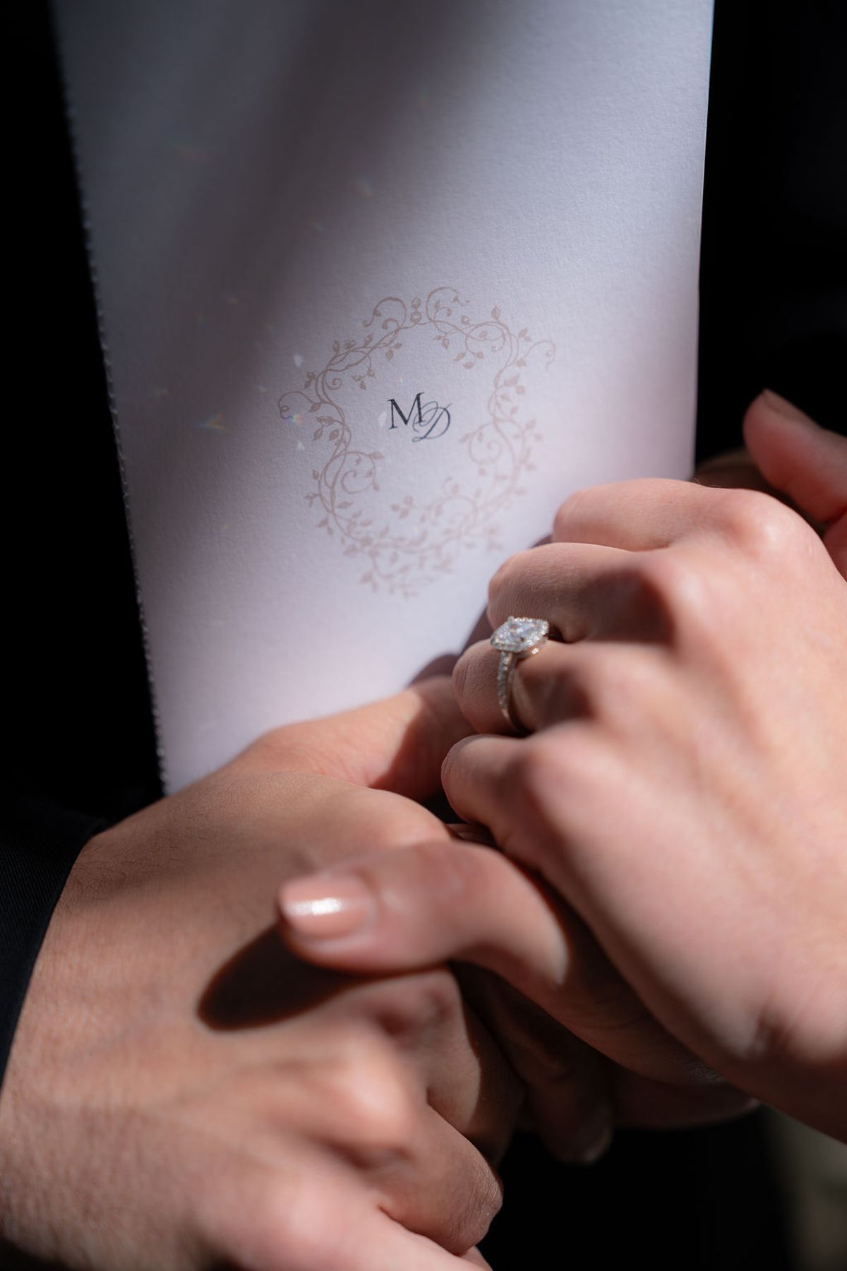 Hands resting on a monogrammed napkin, a solitaire ring visible