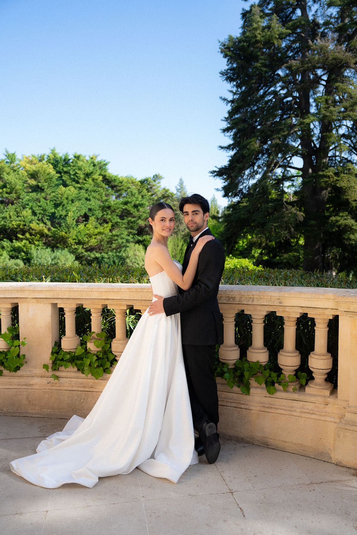 Two dancers on a stone balustrade terrace with parkland behind them