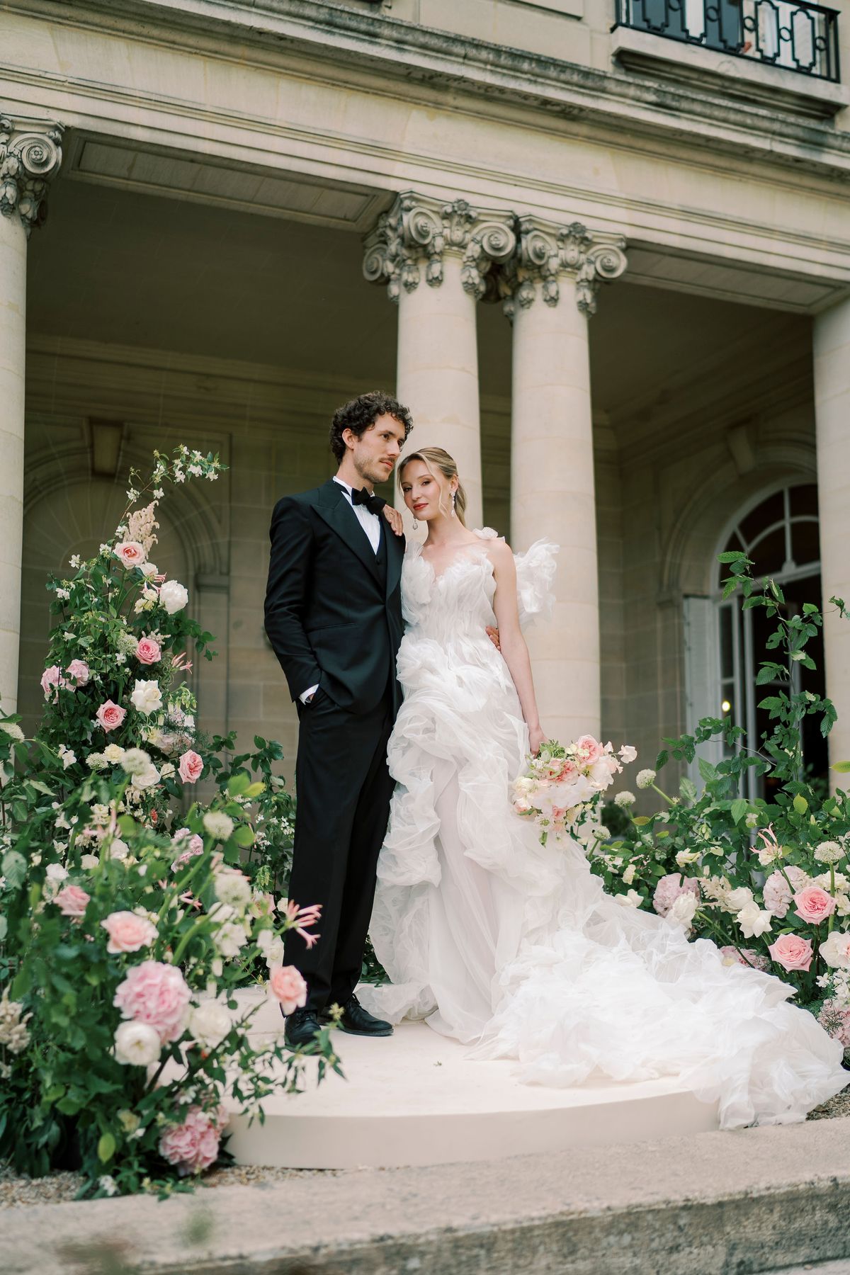 Amélie and Lucien standing on the circular platform among roses and greenery, Château du Prieuré