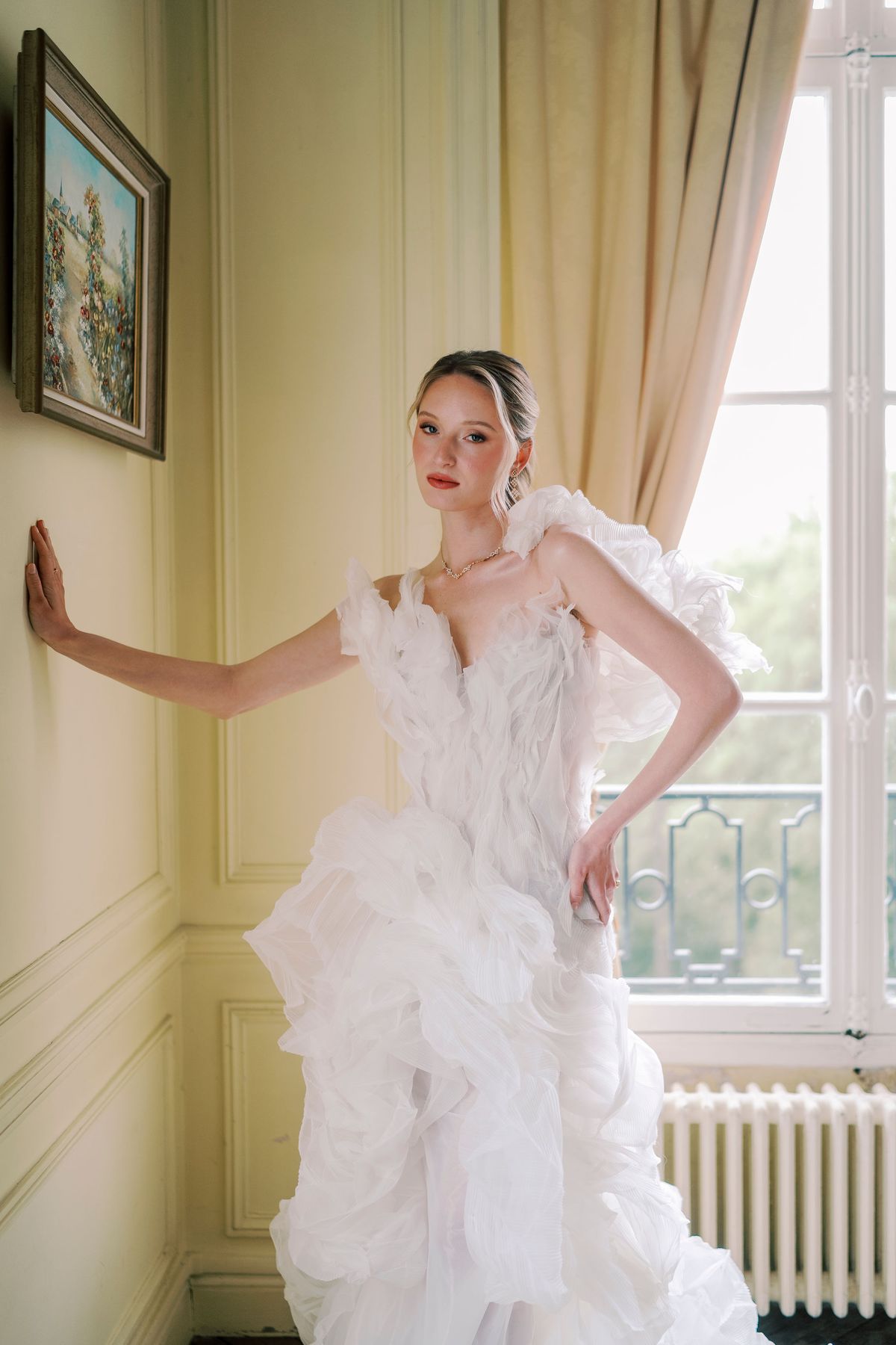 Amélie in her organza gown against the yellow panelled wall of the bridal bedroom, Château du Prieuré