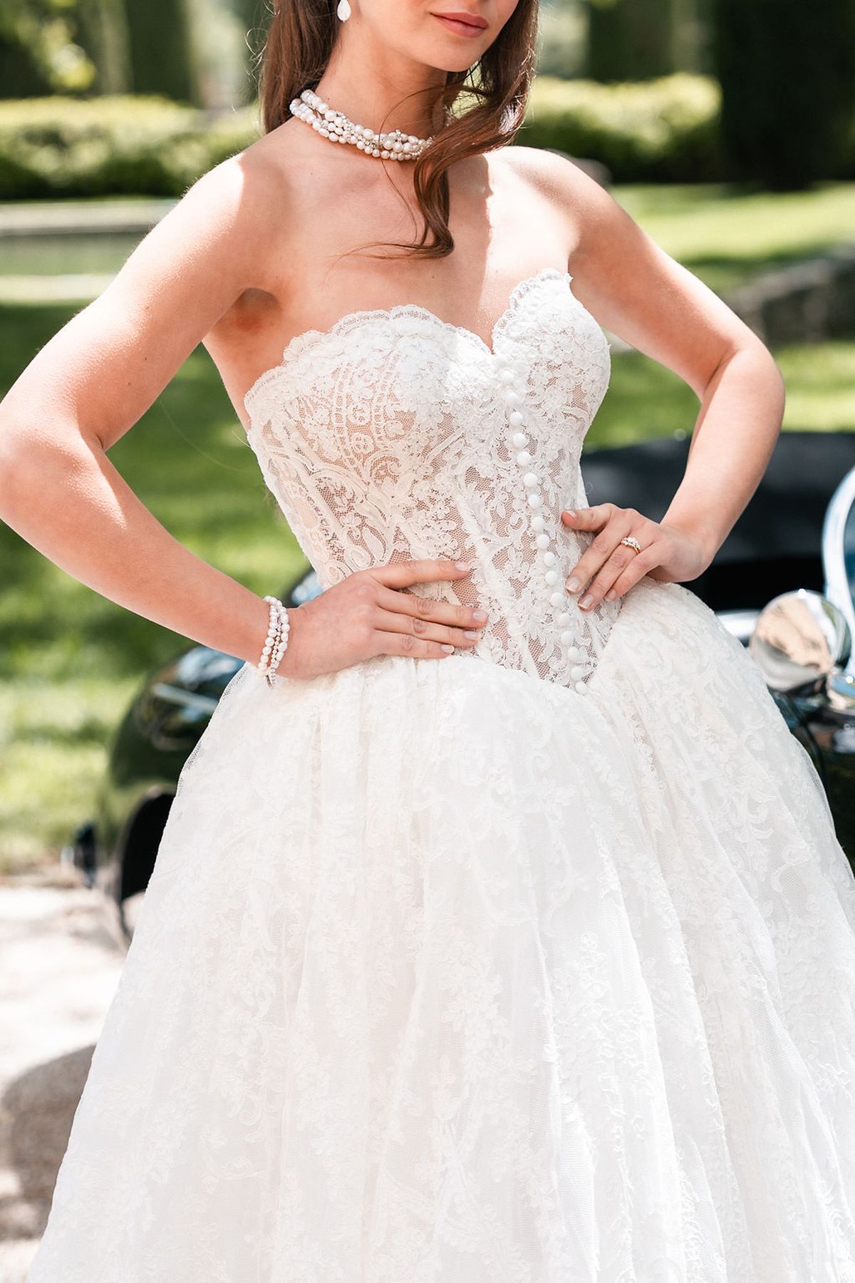 Bride wearing a layered pearl choker above a lace corset bodice at Château de Sannes, Provence