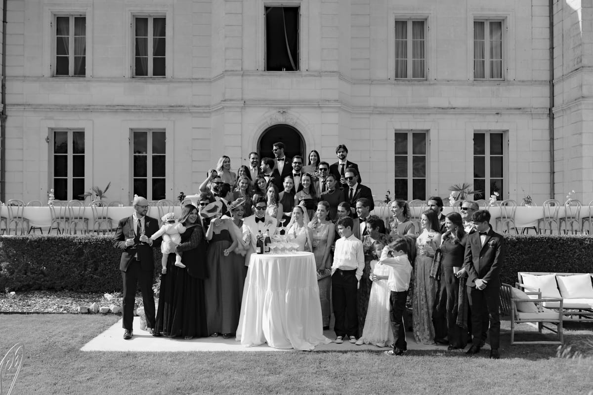 Isadora & Hugo — the wedding party and guests gathered in front of the chateau, spring wedding in Nouvelle-Aquitaine