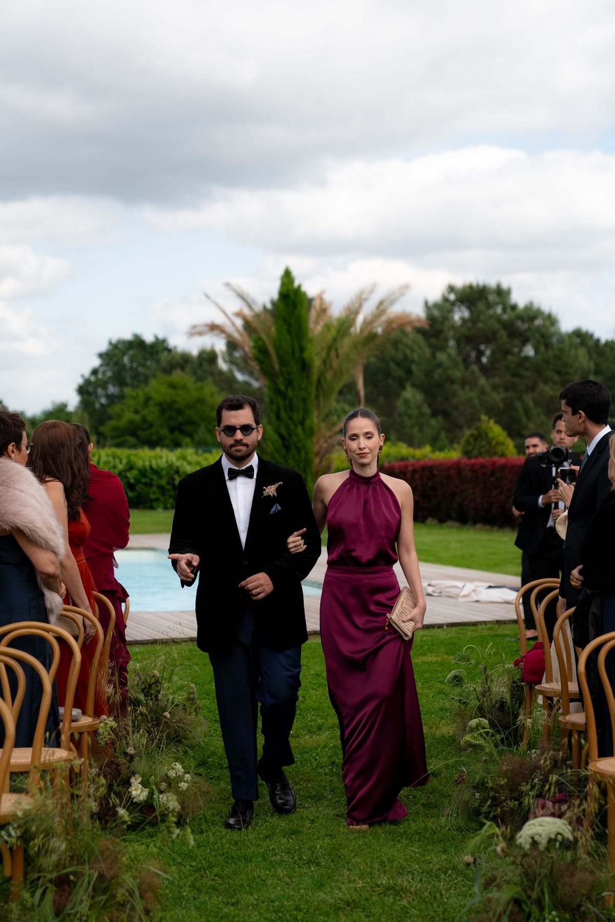 Isadora & Hugo — guests arriving for the ceremony across the lawn, spring wedding in Nouvelle-Aquitaine