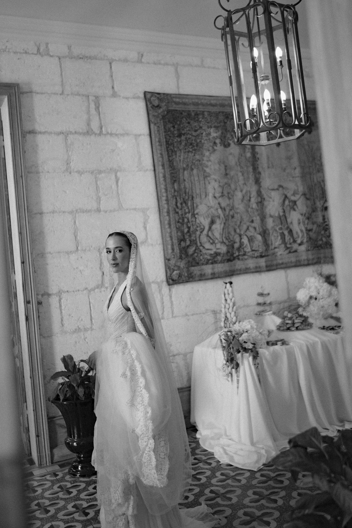 Isadora & Hugo — the bride beside a tapestry in the chateau, spring wedding in Nouvelle-Aquitaine