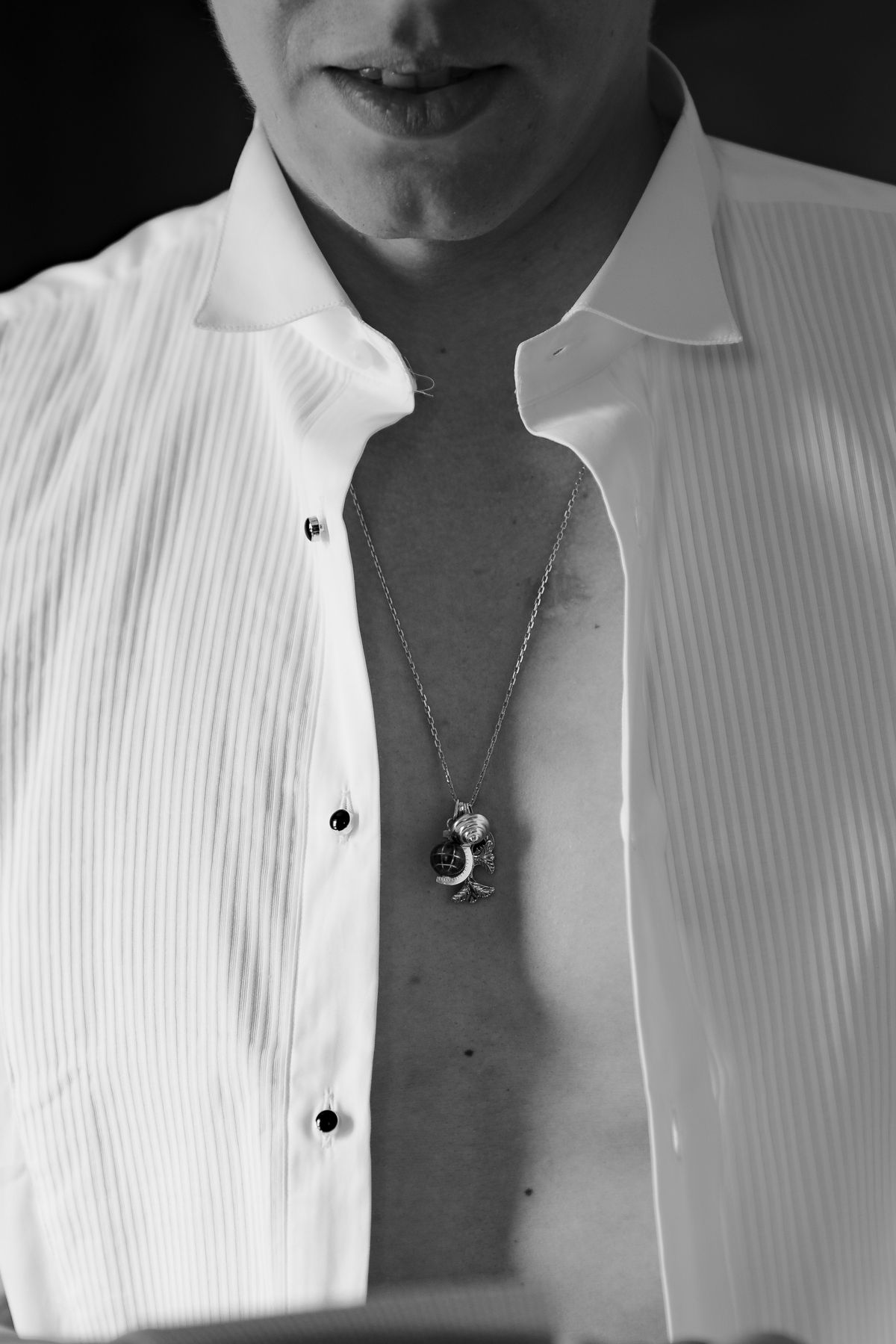 Isadora & Hugo — a close view of the groom's shirt studs and pendant, spring wedding in Nouvelle-Aquitaine