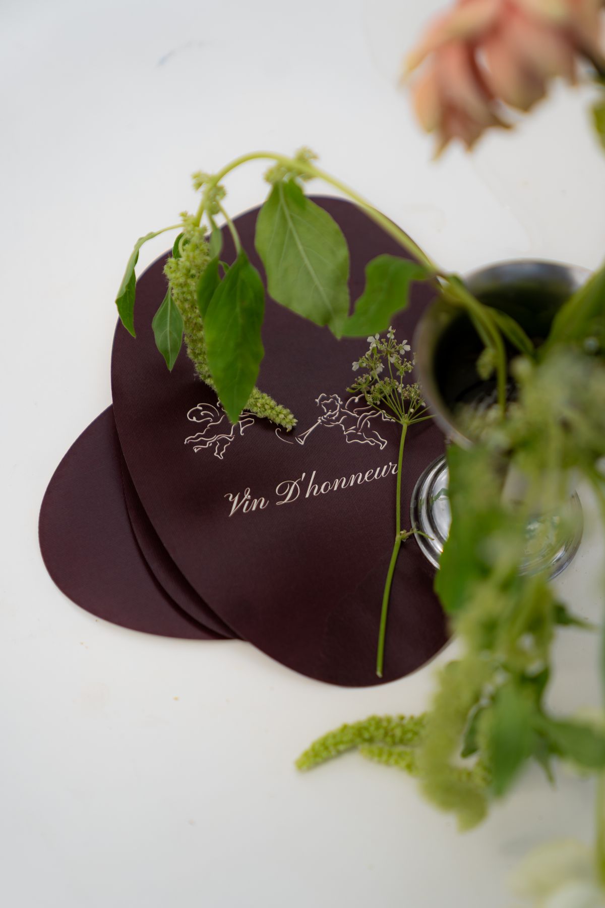 Isadora & Hugo — a burgundy menu card with a sprig of greenery, spring wedding in Nouvelle-Aquitaine