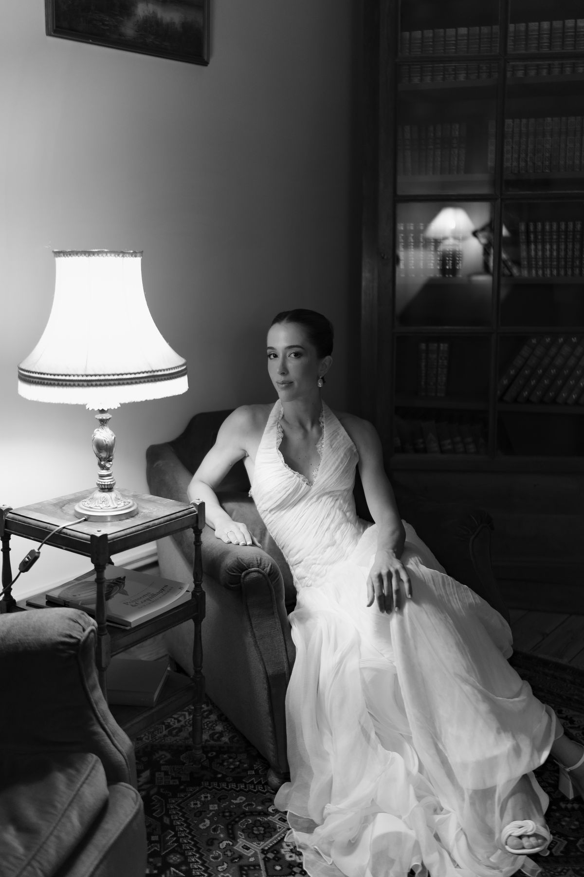 Isadora & Hugo — the bride seated beside a lamp in the chateau salon, spring wedding in Nouvelle-Aquitaine