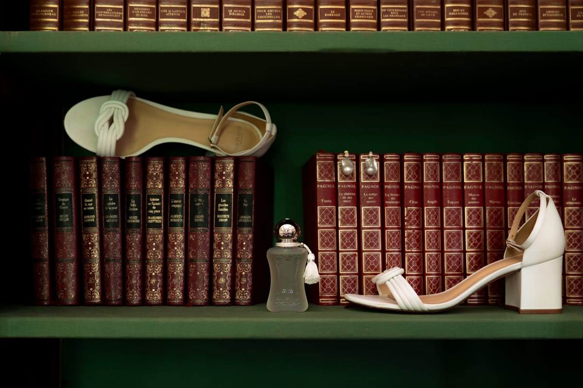 Isadora & Hugo — the bride's heels and perfume on a green shelf of red leather-bound books, spring wedding in Nouvelle-Aquitaine