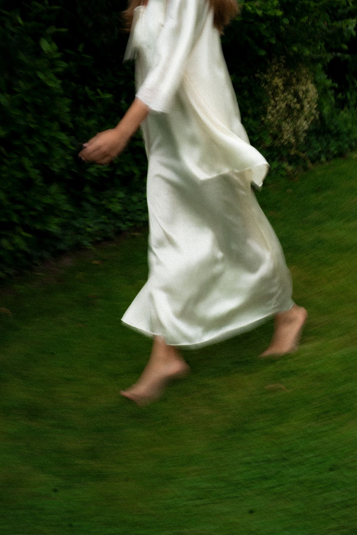 Isadora & Hugo — the bride walking barefoot across the grass in her silk robe, spring wedding in Nouvelle-Aquitaine