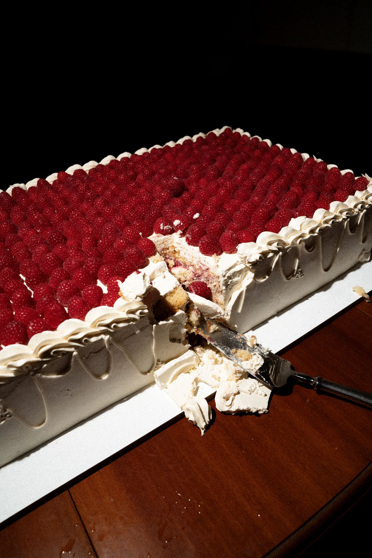 Isadora & Hugo — the raspberry-topped cake being cut, spring wedding in Nouvelle-Aquitaine