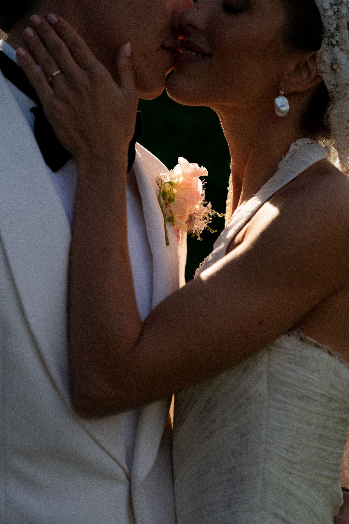 Isadora & Hugo — the couple kissing, the bride's hand at his lapel, spring wedding in Nouvelle-Aquitaine