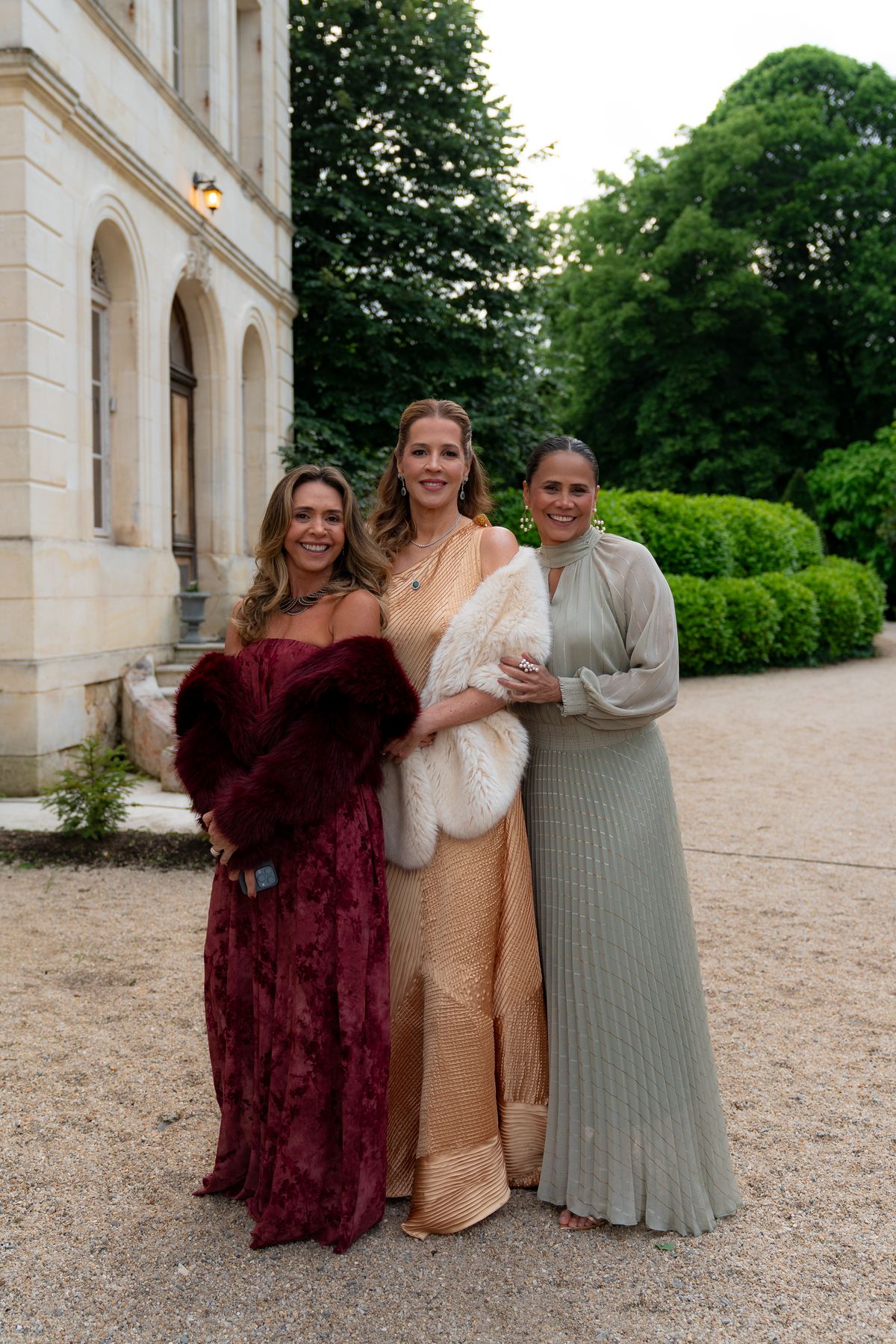 Isadora & Hugo — three guests in evening gowns in front of the chateau, spring wedding in Nouvelle-Aquitaine