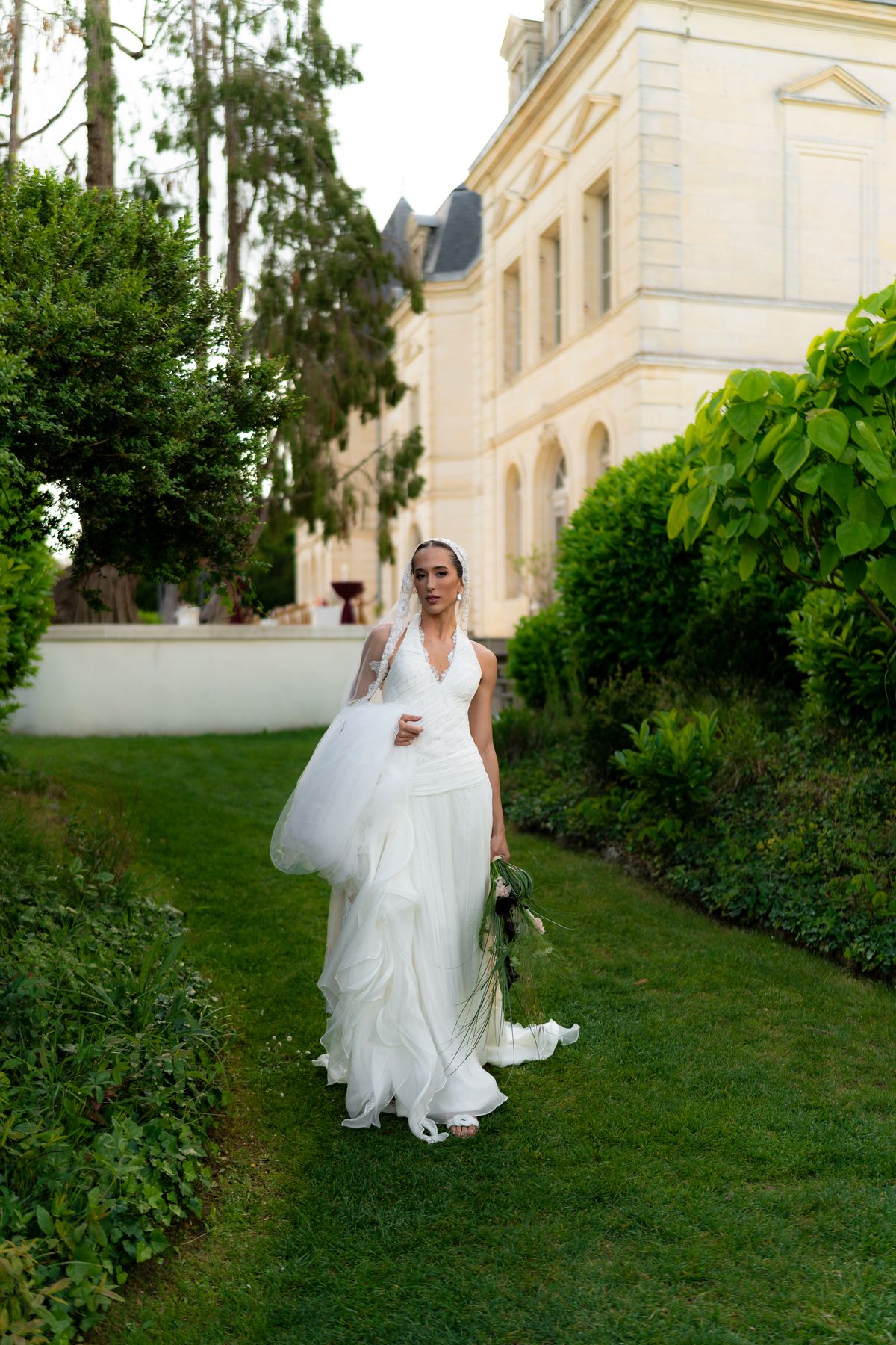 Isadora & Hugo — the bride walking the garden path in her gown, spring wedding in Nouvelle-Aquitaine