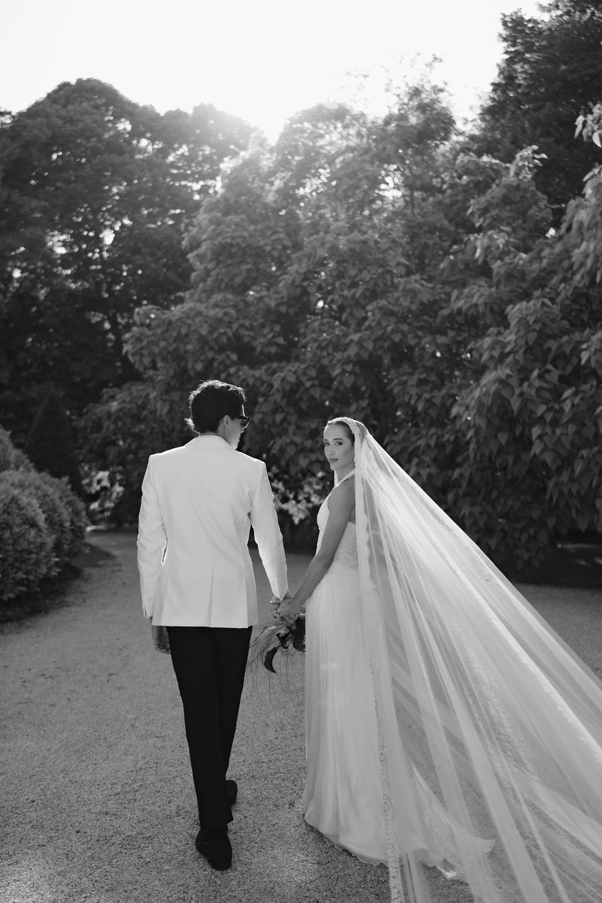 Isadora & Hugo — the couple walking away with the veil trailing behind, spring wedding in Nouvelle-Aquitaine