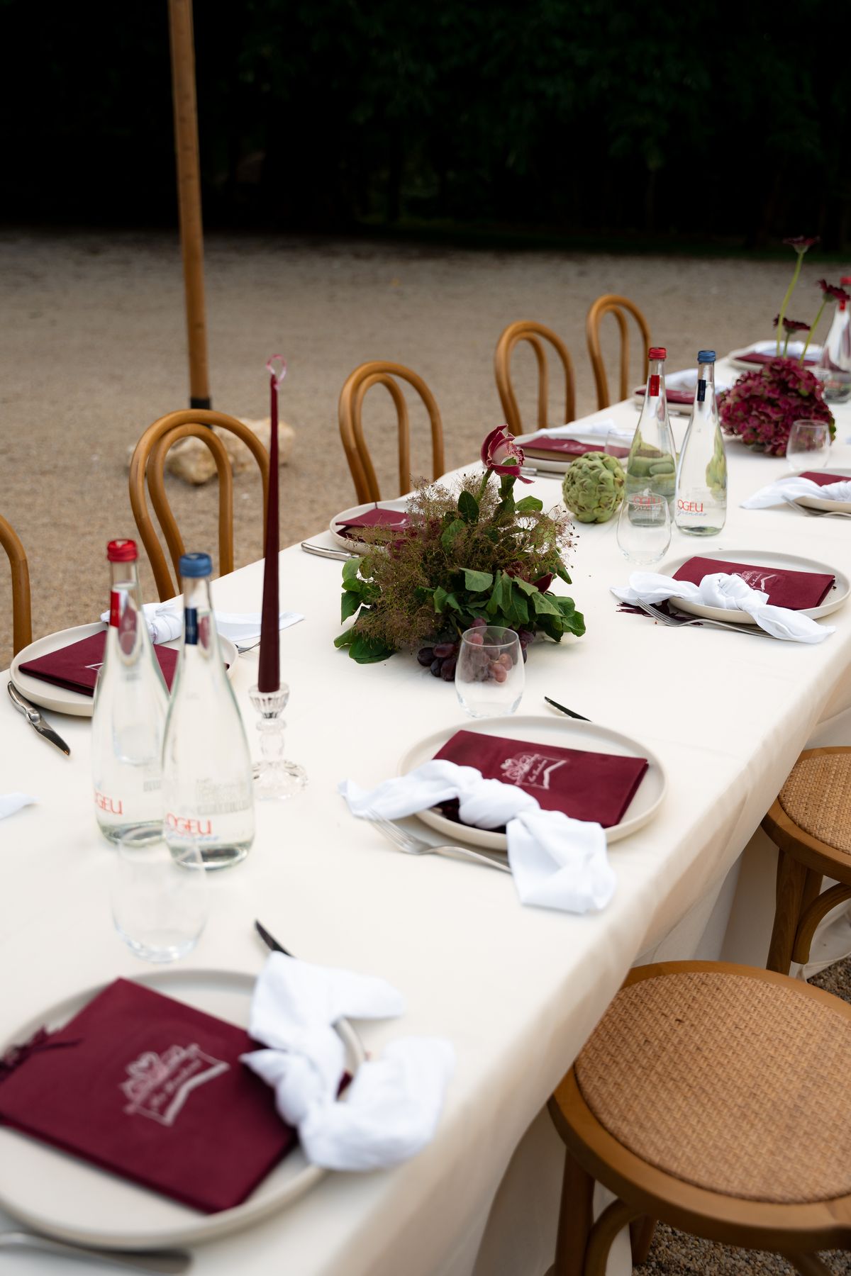 Isadora & Hugo — the long dinner table with tapers, glassware and burgundy menus, spring wedding in Nouvelle-Aquitaine