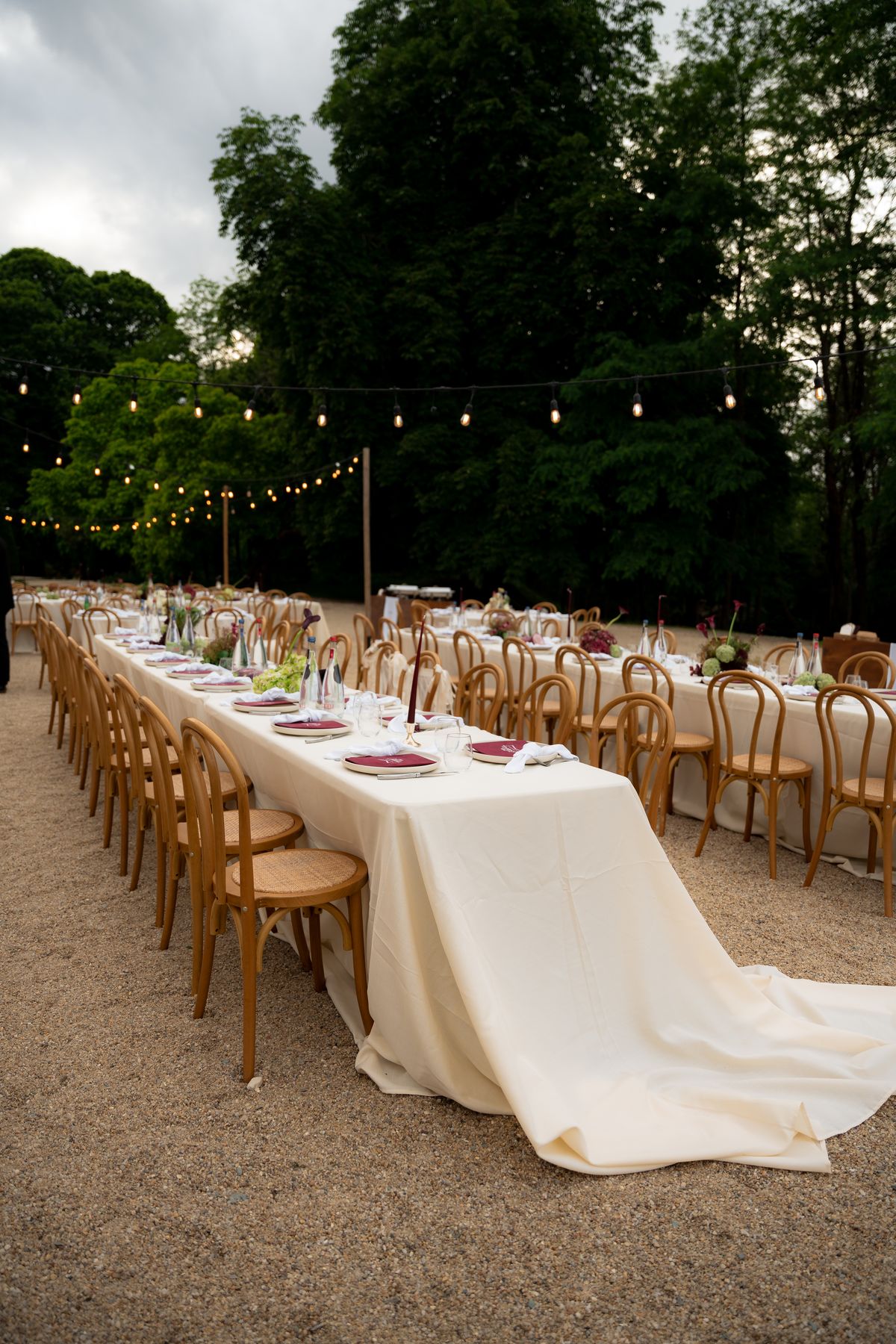 Isadora & Hugo — the outdoor dinner tables beneath festoon lights, spring wedding in Nouvelle-Aquitaine