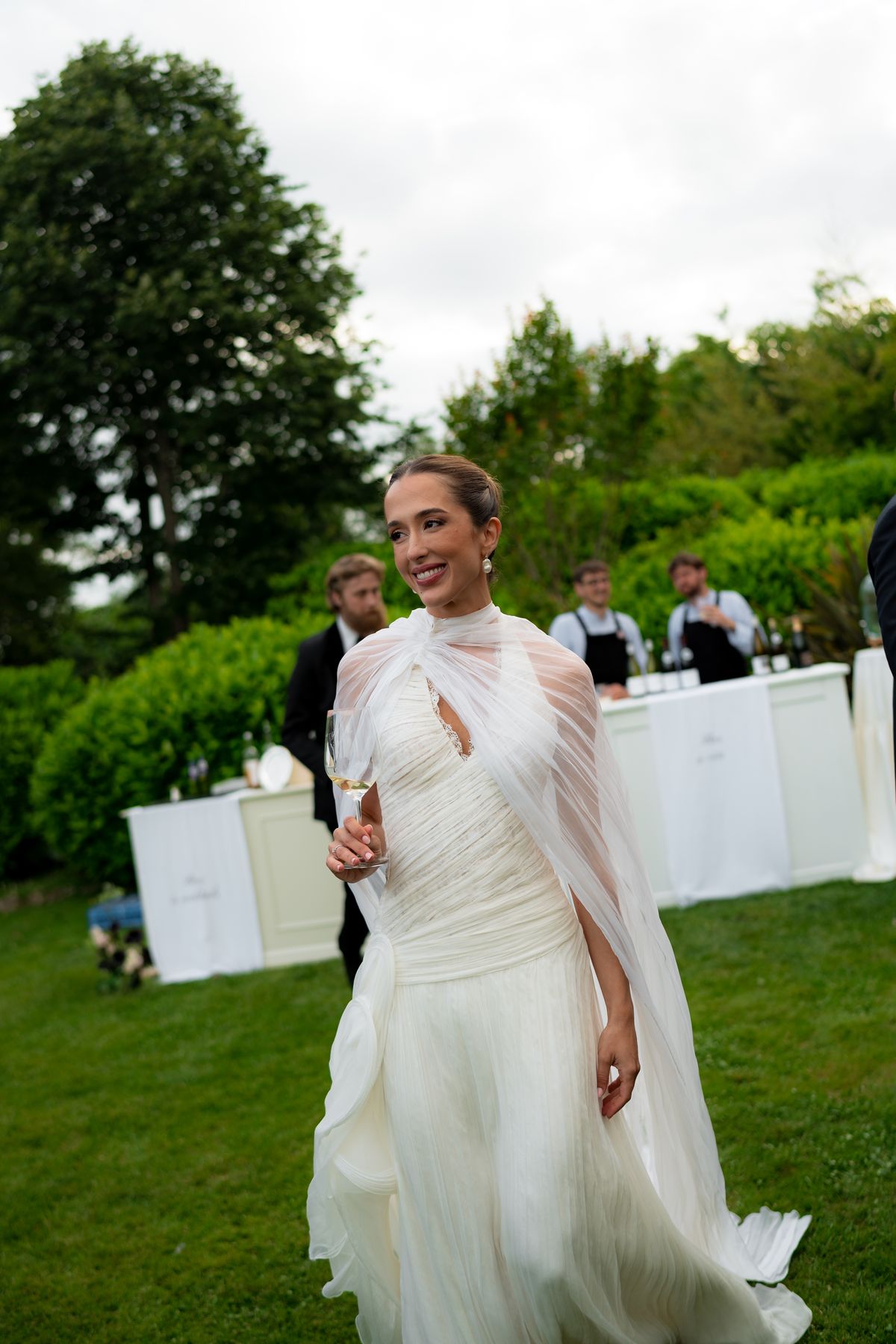Isadora & Hugo — the bride in a caped gown on the lawn, spring wedding in Nouvelle-Aquitaine