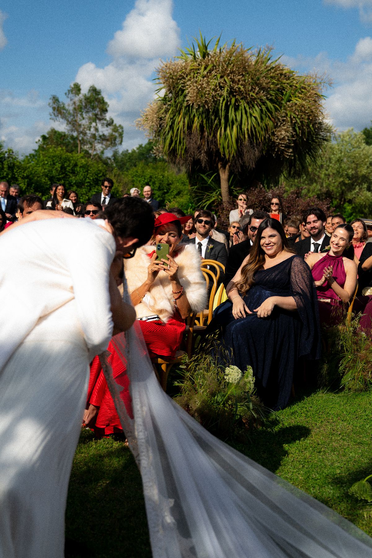 Isadora & Hugo — the bride's veil trailing past the seated guests, spring wedding in Nouvelle-Aquitaine