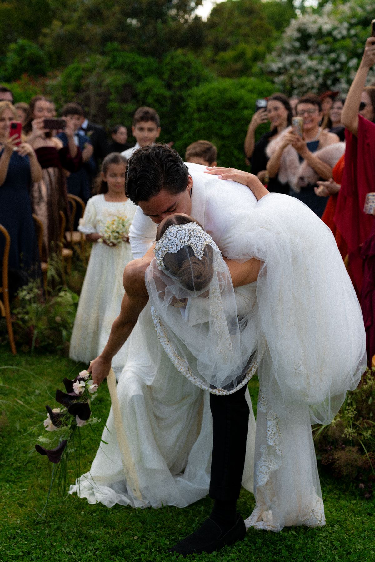 Isadora & Hugo — the groom lifting the bride as guests cheer, spring wedding in Nouvelle-Aquitaine