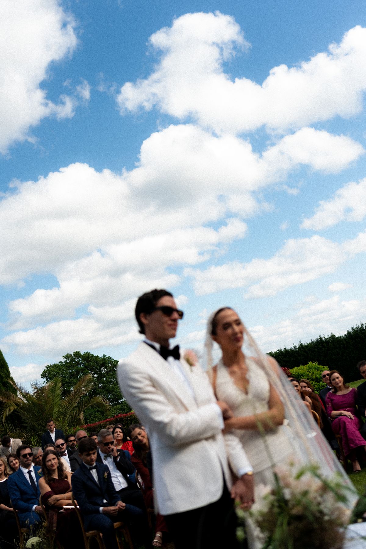 Isadora & Hugo — the couple during the ceremony as guests look on, spring wedding in Nouvelle-Aquitaine