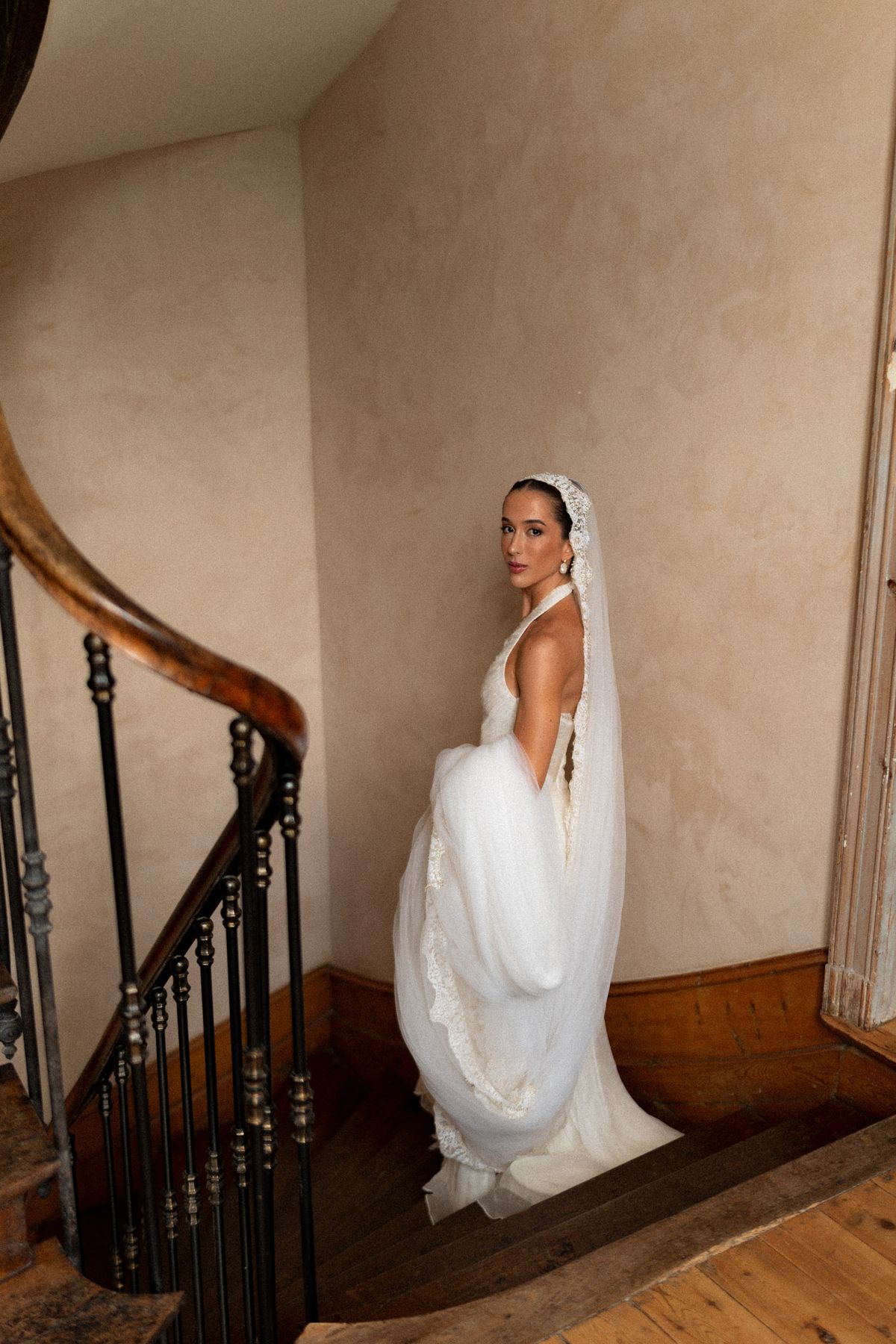 Isadora & Hugo — the bride on the staircase, the back of her gown and veil, spring wedding in Nouvelle-Aquitaine